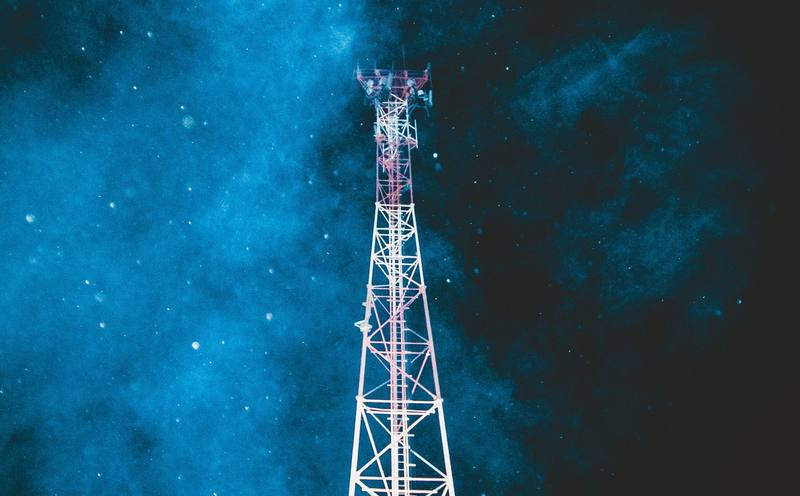 A lattice telecom tower against the night sky